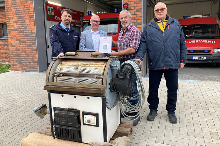Die Ortsfeuerwehr Burgdorf-Schillerslage besitzt die älteste betriebsbereite Gewerbewaschmaschine von Miele in Deutschland. Michael Arendes, Professional-Marketingmanager Wäschereitechnik in der Miele-Vertriebsgesellschaft Deutschland (2.v.l.), überreichte die Siegerurkunde an (v.l.) Ortsbrandmeister Timo Scheffler, Heiner Wehrs (Erster Vorsitzender des Feuerwehr-Fördervereins) und „Restaurator“ Wolfgang Heldt. Foto: Miele